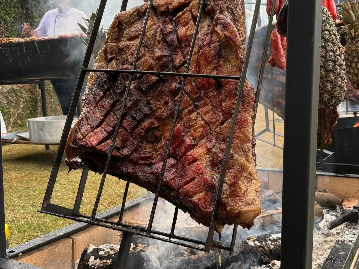 Costela em cruz assando lentamente na brasa