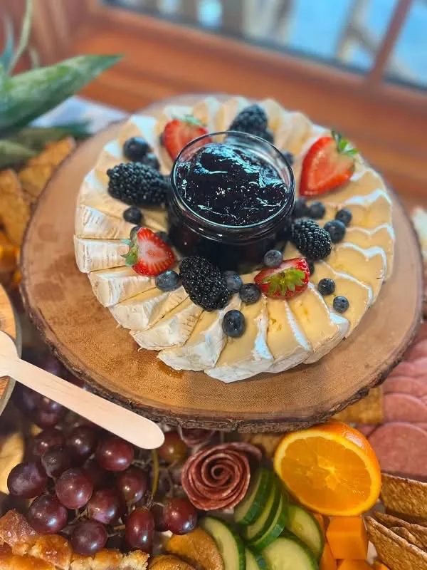 Queijo brie com geleia e frutas vermelhas apresentado na ilha de frios do D’Faria